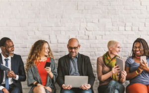 Mobile workforces using handheld devices while sitting against a wall