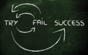 Words try, fail and success written on a chalkboard with arrows showing how they're connected